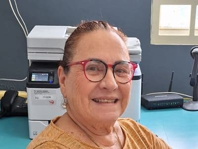 The practice’s administrative assistant at her desk, smiling