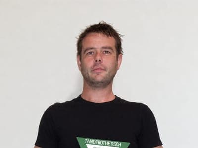Thijs holding the plaque of the Dutch Institute of Dental Prosthetics: qualified denturist, registration number 593